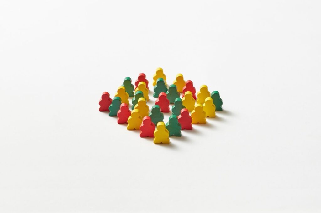 Cluster of multicolored game pawns arranged on a plain white background.